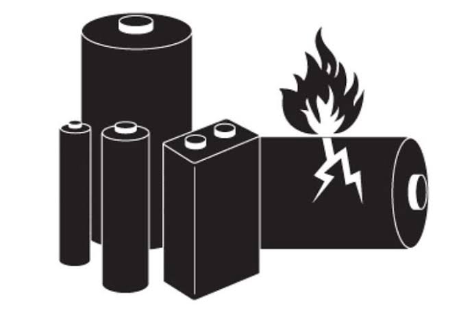 Ilustración de varias baterías de distintos tamaños y formas con símbolos de flamabilidad y riesgo eléctrico, representando el envío de mercancías peligrosas.